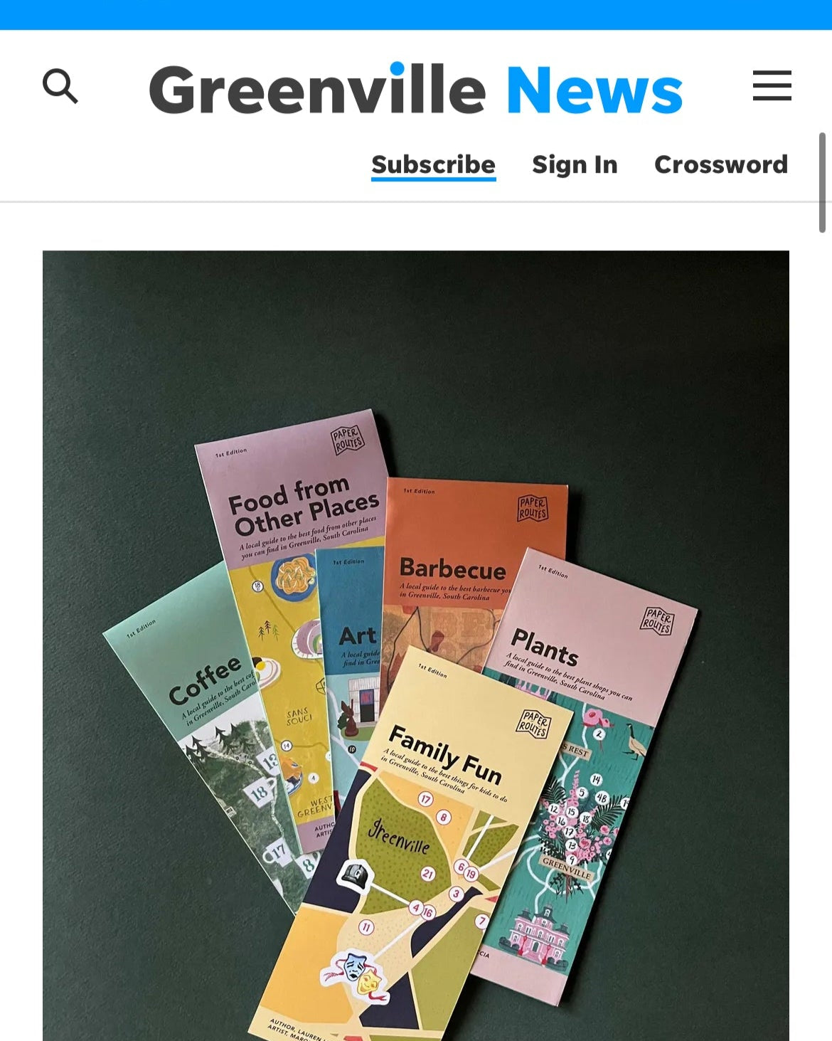 Greenville News webpage with printed maps on a dark background